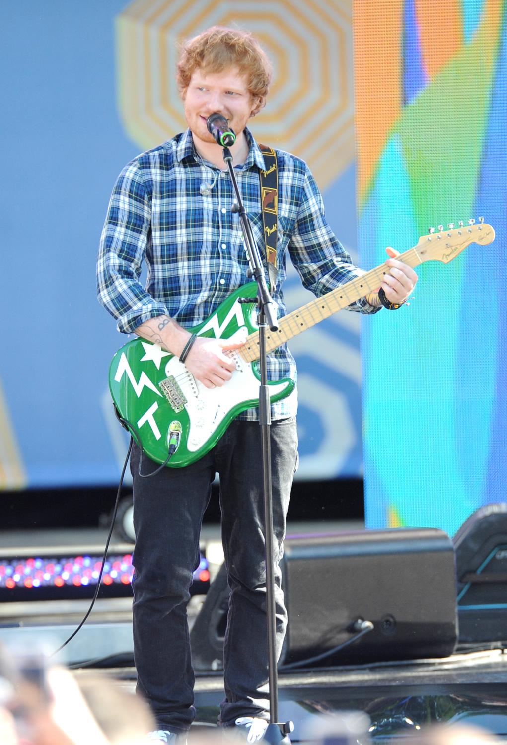 Ed Sheeran playing a unique green Fender Eric Clapton Stratocaster electric guitar by creative director Teddy McDonald  on stage on Multiply world tour.
